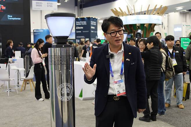 지난달 미국 라스베가스에서 열린 CES 2025에서 로우카본 부스를 찾은 방문객들에게 이철 대표가 직접 자사의 기후테크 혁신기술인 카본트리 앞에서 첨단솔루션을 소개하고 있다.