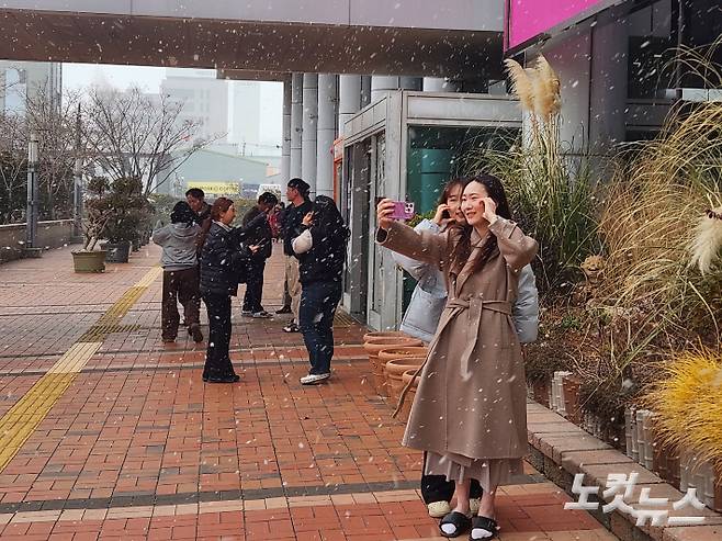 7일 오전 부산에 눈이 내리자 시민들이 즐거운 모습으로 사진을 찍고 있다. 정혜린 기자