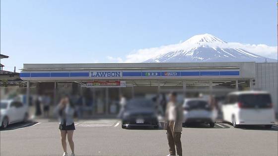 지난해 4월 야마나시현 후지카와구치코 로손 편의점 앞에서 관광객들이 후지산을 배경으로 사진을 찍고 있는 모습. 사진 TV아사히.