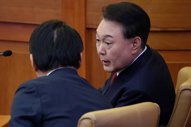윤석열 대통령이 11일 서울 종로구 헌법재판소에서 열린 본인의 탄핵심판 7차 변론에서 배보윤 변호사와 대화하고 있다. 사진공동취재단