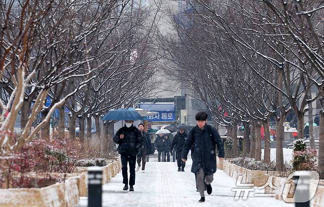 수도권 지역에 대설특보가 발효된 12일 오전 서울 종로구 광화문네거리에서 시민들이 눈을 맞으며 출근길을 서두르고 있다. 2025.2.12/뉴스1 ⓒ News1 김성진 기자