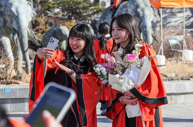 지난 13일 졸업생 최윤영, 구연수씨가 코끼리를 배경으로 활짝 웃으며 셀카를 찍고 있다. /박성원 기자