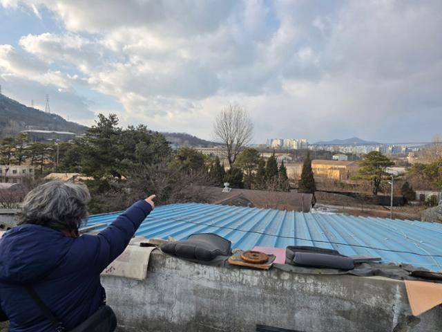 지난달 초 캠프 스탠리와 담 하나를 사이에 두고 마주한 일명 뺏벌 마을에서 김성길 경기북부환경운동연합 사무국장이 헬기장을 손가락으로 가리키고 있다. 임명수 기자