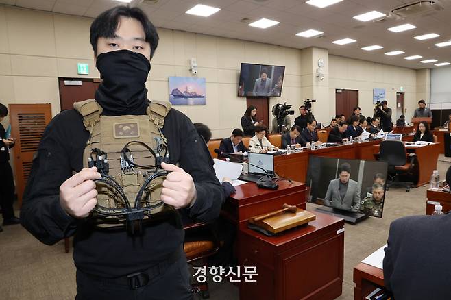 박선원 더불어민주당 의원 보좌직원이 20일 국회 국방위 전체회의에서 707 특임단의 흑복을 입고 당시 소지했던 체포용 케이블타이보여 주고 있다. 김현태 707특임단장은 플라스틱 수갑이 국회 문 봉쇄용이라고 주쟝했다. 박민규 선임기자