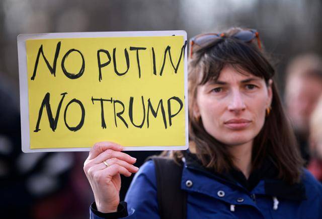 22일 독일 베를린에서 한 여성이 '노 푸틴(블라디미르 푸틴 러시아 대통령), 노 트럼프(도널드 트럼프 미국 대통령)'라고 적힌 팻말을 들고 우크라이나 전쟁 반대 집회에 참가해 있다. 베를린=EPA 연합뉴스