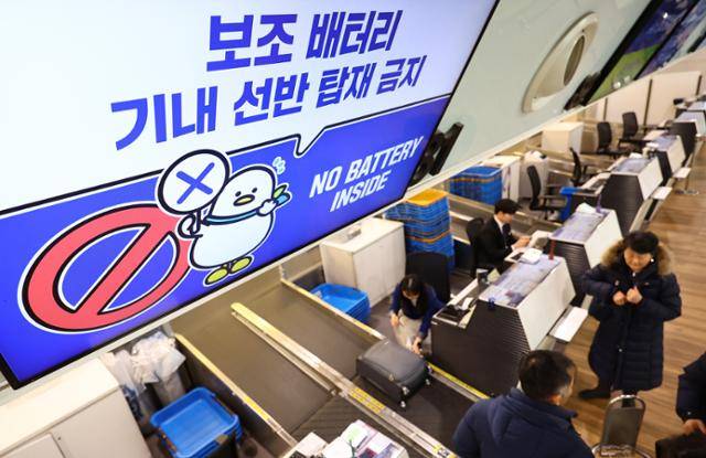 19일 김포국제공항 국내선 청사의 에어부산 탑승수속 카운터에 보조 배터리의 기내 선반 탑재 금지를 알리는 안내물이 표출되고 있다. 뉴시스