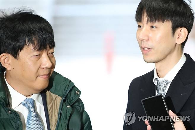 이재웅 전 쏘카 대표(왼쪽)와 타다 운영사 쏘카 박재욱 대표가 당시 여객자동차 운수사업법 위반 혐의로 서울중앙지법에서 열리는 첫 공판에 출석하며 취재진의 질문을 받고 있다. 연합뉴스