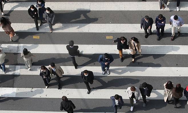 서울 종로구 한 교차로에서 점심시간에 직장인들이 횡단보도를 건너고 있다. 연합뉴스