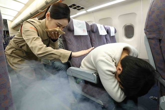 제주항공 객실승무원들이 지난 4일 객실훈련센터에서 기내 화재를 대비한 화재 진압 및 승객 안전 확보 훈련을 하고 있다. (제주항공 제공)