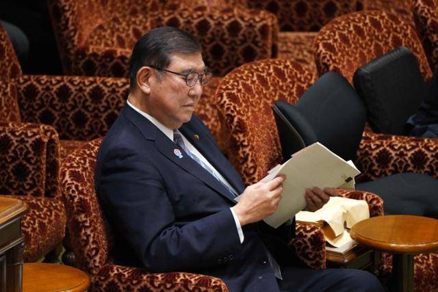 이시바 시게루 일본 총리가 14일 도쿄 국회 참의원 예산위원회에 참석해 자료를 보며 기다리고 있다. 도쿄=AFP 연합뉴스