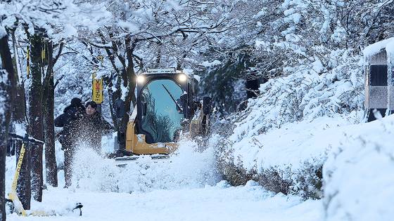 강원 동해안에 대설특보 속에 많은 눈이 내린 17일 강릉시 교동에서 제설차가 인도의 눈을 치우느라 바쁜 모습이다. 연합뉴스