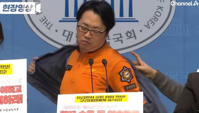 지난 17일 국회의원회관에서 열린 기자회견에서 ‘노조’ 조끼를 벗는 김성현 전국공무원노조 서울소방지부 구급국장의 모습 (사진=채널A 영상 캡처)