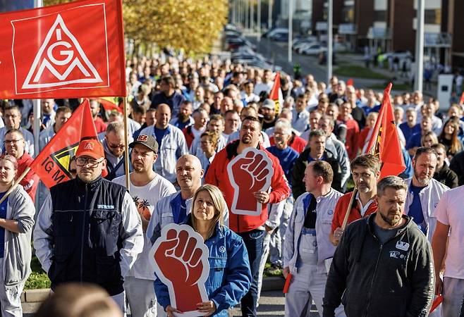 2024년 10월 28일(현지시간) 독일 동부 츠비카우에 있는 폭스바겐 작센 공장 근로자들이 깃발을 든 채 시위하고 있다. 폭스바겐은 부진한 경영 실적 탓에 독일 내 공장 최소 세 곳을 폐쇄하고 일자리 수만 개를 감축한다는 방침을 밝혔다. 사진=연합뉴스