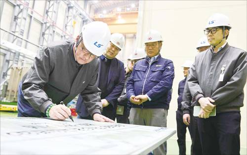 구자균 LS일렉트릭 회장이 지난해 KOC전기 증설 공장의 초고압 변압기 초도 생산을 기념하는 사인보드에 서명하는 모습. (LS일렉트릭 제공)