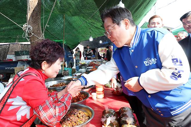 더불어민주당 이재명 대표가 22일 오전 전남 담양시장에서 이재종 후보 지원 유세를 하면서 상인과 악수를 하고 있다. <연합뉴스>