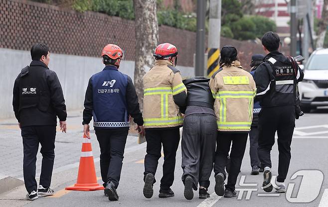 25일 서울 강동구 대명초등학교 인근 사거리에서 발생한 대형 싱크홀(땅 꺼짐) 사고로 매몰된 30대 오토바이 운전자의 유가족이 소방대원들의 부축을 받으며 이동하고 있다. 2025.3.25/뉴스1 ⓒ News1 김성진 기자