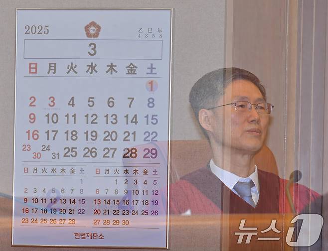 문형배 헌법재판소장 권한대행이 27일 서울 종로구 헌법재판소에서 열린 3월 헌법소원 심판 등 일반 사건 선고에 참석해 자리하고 있다. 사진은 심판정 내부에 있는 달력과 다중노출 촬영. (공동취재) 2025.3.27/뉴스1 ⓒ News1 김성진 기자