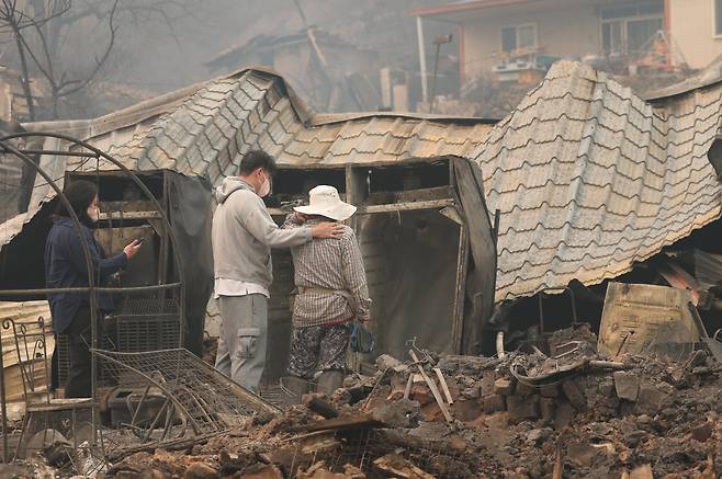모두 타 내려앉은 집 앞에서 망연자실 - 26일 오후 경북 영양군의 한 마을에서 주민 2명이 산불에 타버린 집을 바라보고 있다. 22일 경북 의성에서 시작된 산불은 안동, 청송, 영양까지 번졌다. 산림 당국은 경북 지역에서만 주택, 공장, 창고 등 최소 234곳 건물이 불에 탄 것으로 파악하고 있다. /뉴스1