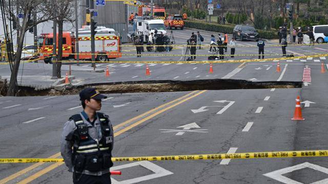 24일 서울 강동구 한영외고 앞 도로에서 지름 20m, 깊이 18m가량의 대형 싱크홀(땅 꺼짐)이 발생해 25일 경찰이 사고 현장을 통제하고 있다. 하상윤 기자