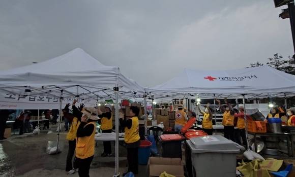 ‘의성에 기다리던 비’ - 27일 경북 의성군 산림청 산불 현장 지휘 본부 일대에 비가 내리자 자원봉사자들이 환호성을 내지르고 있다. 2025.3.27 연합뉴스