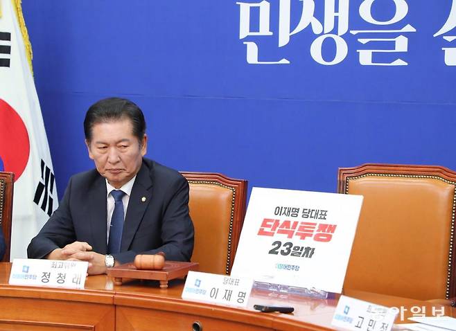 이재명 대표의 체포동의안이 가결된 다음 날인 다음 날인 2023년 9월 22일 민주당 최고위원회의 자리에서 정청래 최고위원이 이재명 대표의 빈 자리와 ‘단식투쟁 23일차’라고 쓰여진 피켓을 바라보고 있다. 이날 정 최고위원은 체포동의안 국회 표결에서 찬성표를 행사한 소속 의원들을 겨냥해선 “가증스럽다”고 직격탄을 날렸다. 당시 원내대표로 있던 비명계 박광온 의원은 가결 직후 원내대표직을 사임했다. 동아일보DB