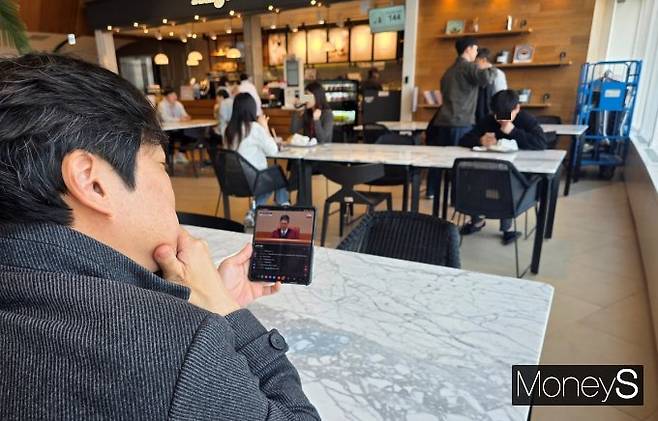 4일 오전 11시 강남의 한 직장 내 카페에서 임직원들이 휴대폰으로 윤석열 대통령 탄핵선고 방송을 시청하고 있다. /사진=황정원 기자