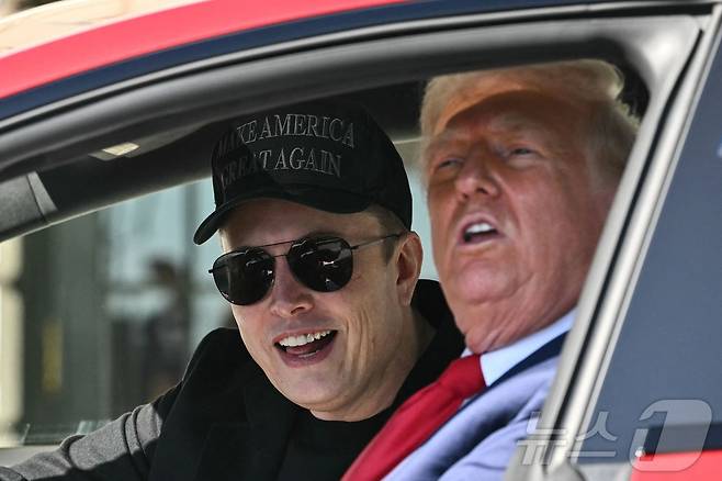 도널드 트럼프 미국 대통령이 11일 (현지시간) 워싱턴 백악관에서 일론 머스크 테슬라 CEO와 빨간색 테슬라 모델 S 세단에 시승을 하고 있다. 2025.03.12 ⓒ AFP=뉴스1 ⓒ News1 우동명 기자
