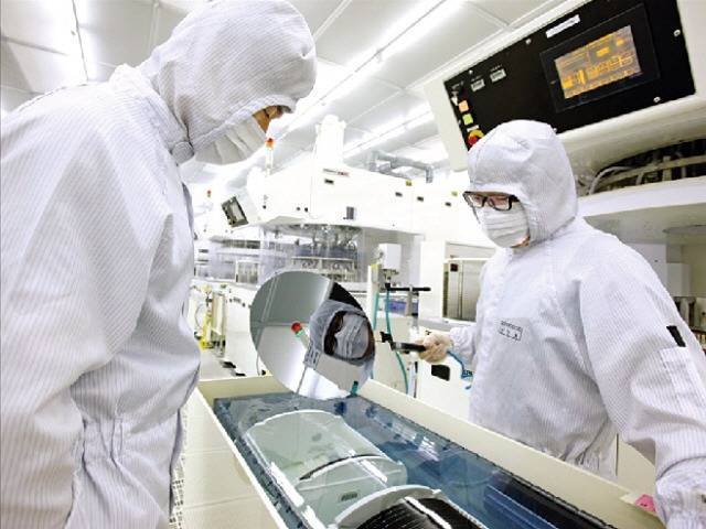 SK실트론 직원들이 웨이퍼 제품을 살피고 있다. /한경DB