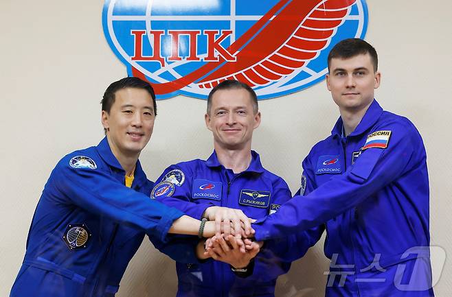 NASA 우주인 조니 김(왼쪽부터), 로스코스모스 우주비행사 세르게이 리지코프, 알렉세이 주브리츠키가 카자흐스탄의 바이코누르 우주기지에서 소유즈 MS-27 우주선 탑승을 앞두고 손을 맞잡고 있다. ⓒ 로이터=뉴스1