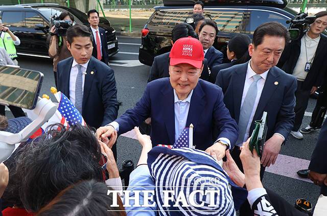 윤석열 전 대통령이 11일 오후 서울 용산구 대통령 관저에서 나와 지지자로부터 받은 'Make Korea Great Again'(다시 한국을 위대하게)라고 적힌 빨간 캡 모자를 쓰고 인사를 하고 있다. /서예원 기자