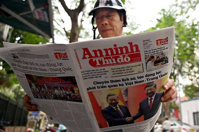 14일 베트남 하노이에서 한 시민이 시진핑 중국 국가주석의 현지 방문을 보도한 신문을 읽고 있다./AFP 연합뉴스