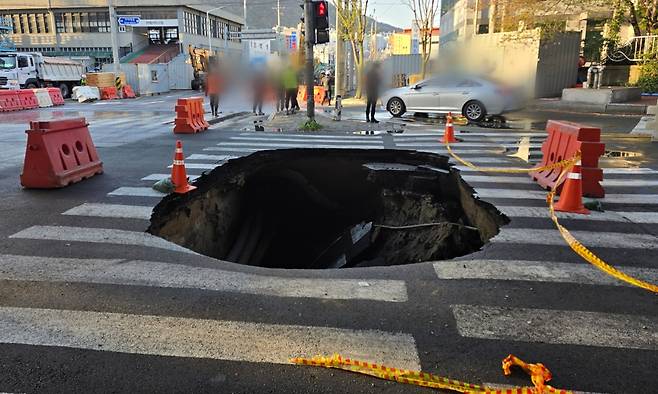 13일 부산 사상구 학장동의 한 횡단보도에서 가로 5m·세로 3m·깊이 4.5m 크기의 땅꺼짐이 발생했다. 부산경찰청 제공