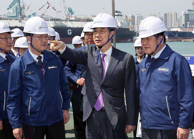 한덕수 대통령 권한대행 국무총리가 16일 HD현대중공업 울산 조선소에서 HD현대중공업 권오갑 회장(오른쪽) 등과 정조대왕급 2번함 '다산정약용함' 설명을 듣고 있다./연합뉴스