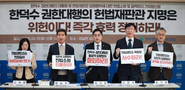 경제정의실천시민연합이 15일 서울 종로구 사무실에서 한덕수 대통령 권한대행 국무총리의 헌법재판관 임명행위 헌법소원 기자회견에서 손팻말을 들고 구호를 외치고 있다. 뉴시스