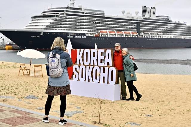 ▲ 19일 속초항에 입항한 노르담호 선객들이 하선후 아바이마을에서 기념촬영을 하고 있다.