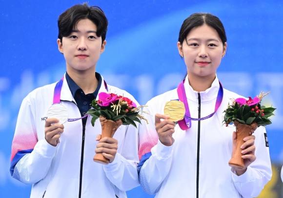 한국 양궁 국가대표 임시현이 2023년 10월 7일 중국 항저우 푸양 인후 스포츠센터에서 열린 2022 항저우 아시안게임 양궁 리커브 여자 개인 결승전에서 우승을 차지한 뒤 준우승한 안산과 세레머니하고 있다. 항저우 오장환 기자