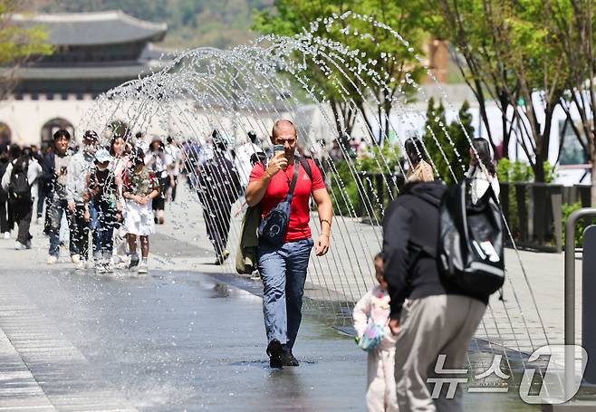 봄철 마지막 절기 곡우(穀雨)인 20일 서울 광화문광장에서 시민과 관광객들이 분수터널을 지나고 있다. .2025.4.20/뉴스1 ⓒ News1 허경 기자