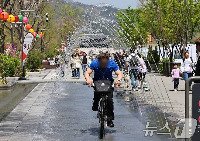 봄철 마지막 절기 곡우(穀雨)인 20일 서울 광화문광장에서 시민과 관광객들이 분수터널을 지나고 있다. .2025.4.20/뉴스1 ⓒ News1 허경 기자