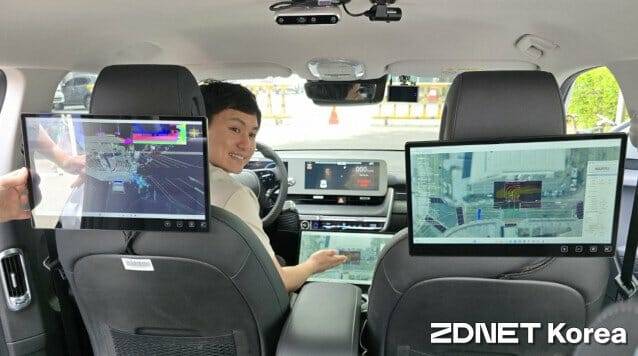 ETRI가 선보인 아이오닉 자율주행차량 내부. ETRI 연구원이 기능을 설명 중이다.