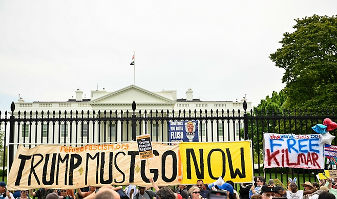 19일(현지시간) 미국 워싱턴DC 백악관 앞에서 시위대가 도널드 트럼프 대통령을 비판하는 시위를 열고있다. ⓒAFP/연합뉴스