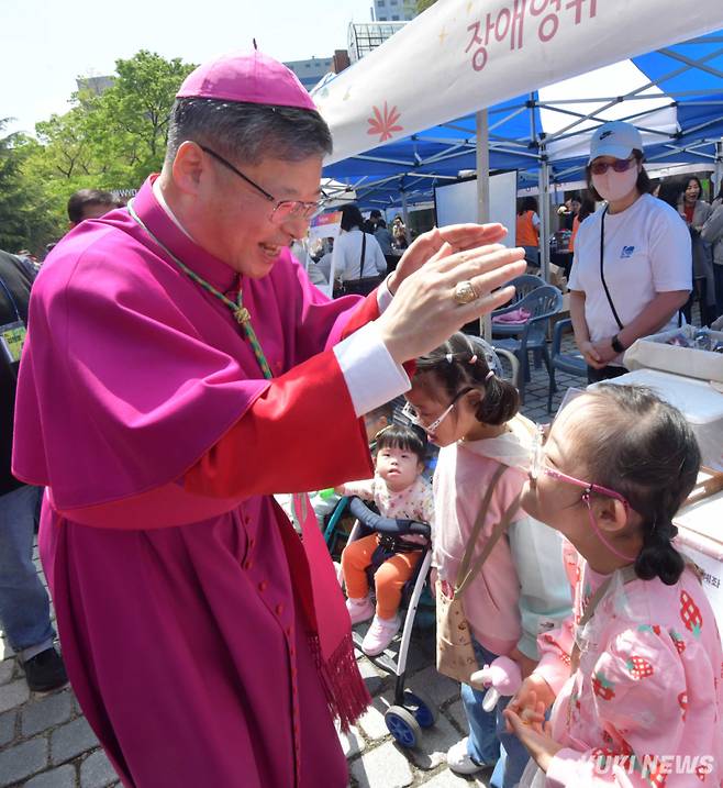 20일 주님 부활 대축일을 맞아 천주교 서울대교구장 정순택 대주교가 명동성당 앞에서 펼쳐진 명동부활축제 현장을 돌아보다 장애인 어린이를 위해 기도하고 있다.