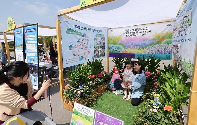 4월 22일 지구의 날을 기념해 '우리의 힘, 우리의 지구'란 주제로 20일 서울 여의도공원에서 열린 '2025 지구의 날 기념행사'를 찾은 가족이 서울국제정원박람회 부스에서 기념촬영하고 있다.