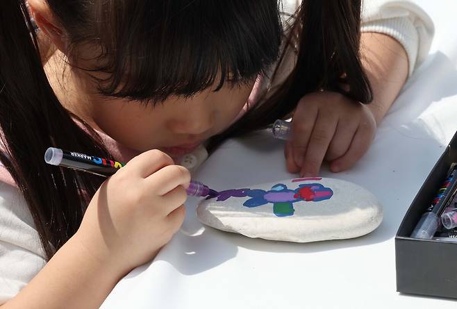 4월 22일 지구의 날을 기념해 '우리의 힘, 우리의 지구'란 주제로 20일 서울 여의도공원에서 열린 '2025 지구의 날 기념행사'를 찾은 어린이가 서울국제정원박람회 부스에서 방명돌을 만들고 있다.