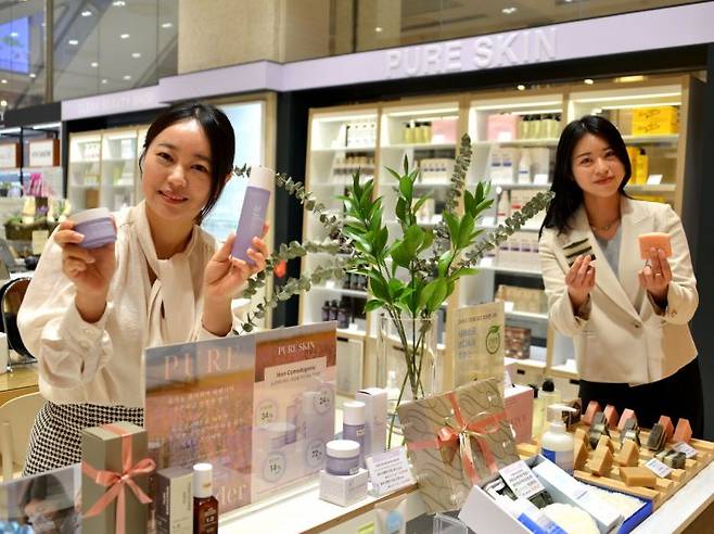 롯데백화점 센텀시티점 지하1층에 입점한 로컬 화장품 브랜드 ‘퓨어스킨’의 직원들이 피부 트러블에 효과적인 대표 상품들을 소개하고 있다. 롯데백화점 제공