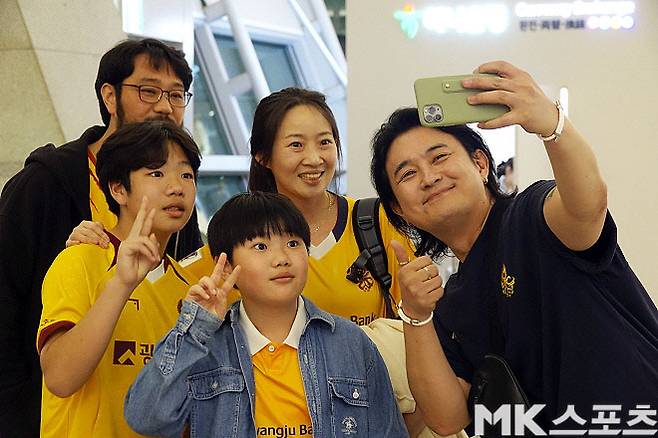 김진옥 씨의 가족이 광주 FC를 함께 응원하고 있는 유명 가수 노라조의 조 빈 씨와 사진을 찍고 있다. 사진=이근승 기자