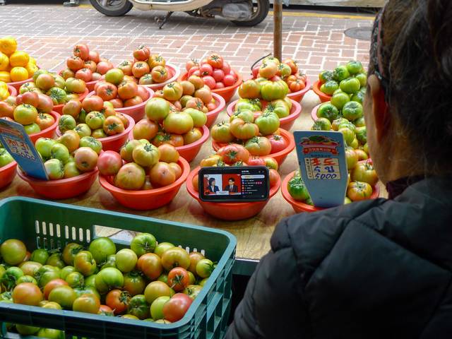 20일 부산 사하구 괴정시장에서 황모(63) 씨가 손님을 기다리며 국민의힘 1차 대선 경선 토론회를 시청하고 있다.