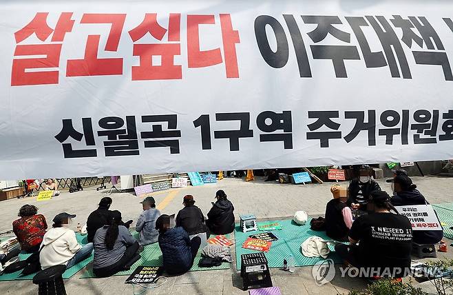 미아리 성노동자 이주대책 마련 촉구집회 (서울=연합뉴스) 김인철 기자 = 17일 서울 성북구청 앞에서 열린 미아리 성노동자 이주대책 마련 촉구 집회에서 참가자들이 현수막 아래에 앉아있다. 2025.4.17 yatoya@yna.co.kr