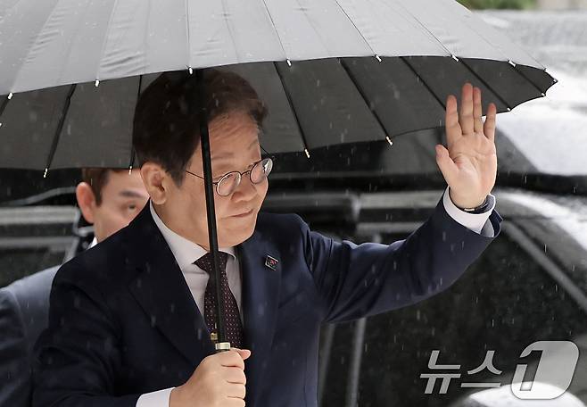 대권 도전에 나선 이재명 더불어민주당 전 대표가 22일 오전 서울 서초구 서울중앙지방법원에서 열린 '대장동 배임 및 성남FC 뇌물' 1심 속행 공판에 출석하며 지지자들에게 손인사를 하고 있다. 2025.4.22/뉴스1 ⓒ News1 오대일 기자