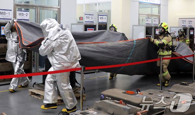 11일 오후 제주시 아라동 전기차배터리산업화센터에서 민관 합동으로 열린 화재 대응 훈련에서 소방관들이 전기차 리튬 배터리에 질식소화포를 덮고 있다. 2024.7.11/뉴스1 ⓒ News1 고동명 기자