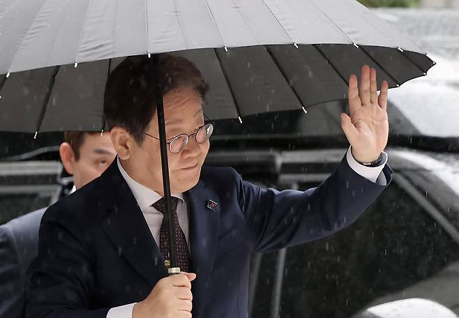 대권 도전에 나선 이재명 더불어민주당 전 대표가 22일 오전 서울 서초구 서울중앙지방법원에서 열린 '대장동 배임 및 성남FC 뇌물' 1심 속행 공판에 출석하며 지지자들에게 손인사를 하고 있다./뉴스1